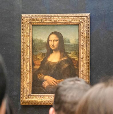 Mona Lisa displayed at the Louvre Museum, Paris, with visitors viewing the painting.