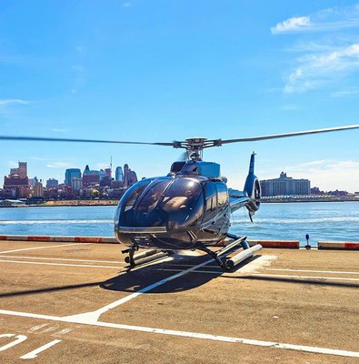 Helicopter on a helipad with New York City skyline in the background.